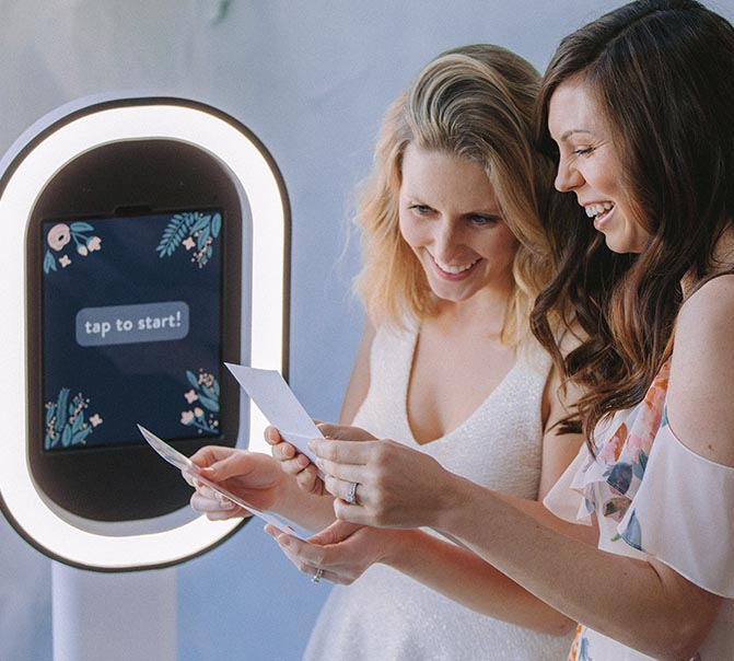 Twee vrouwen bekijken hun photobooth print van 321Klik